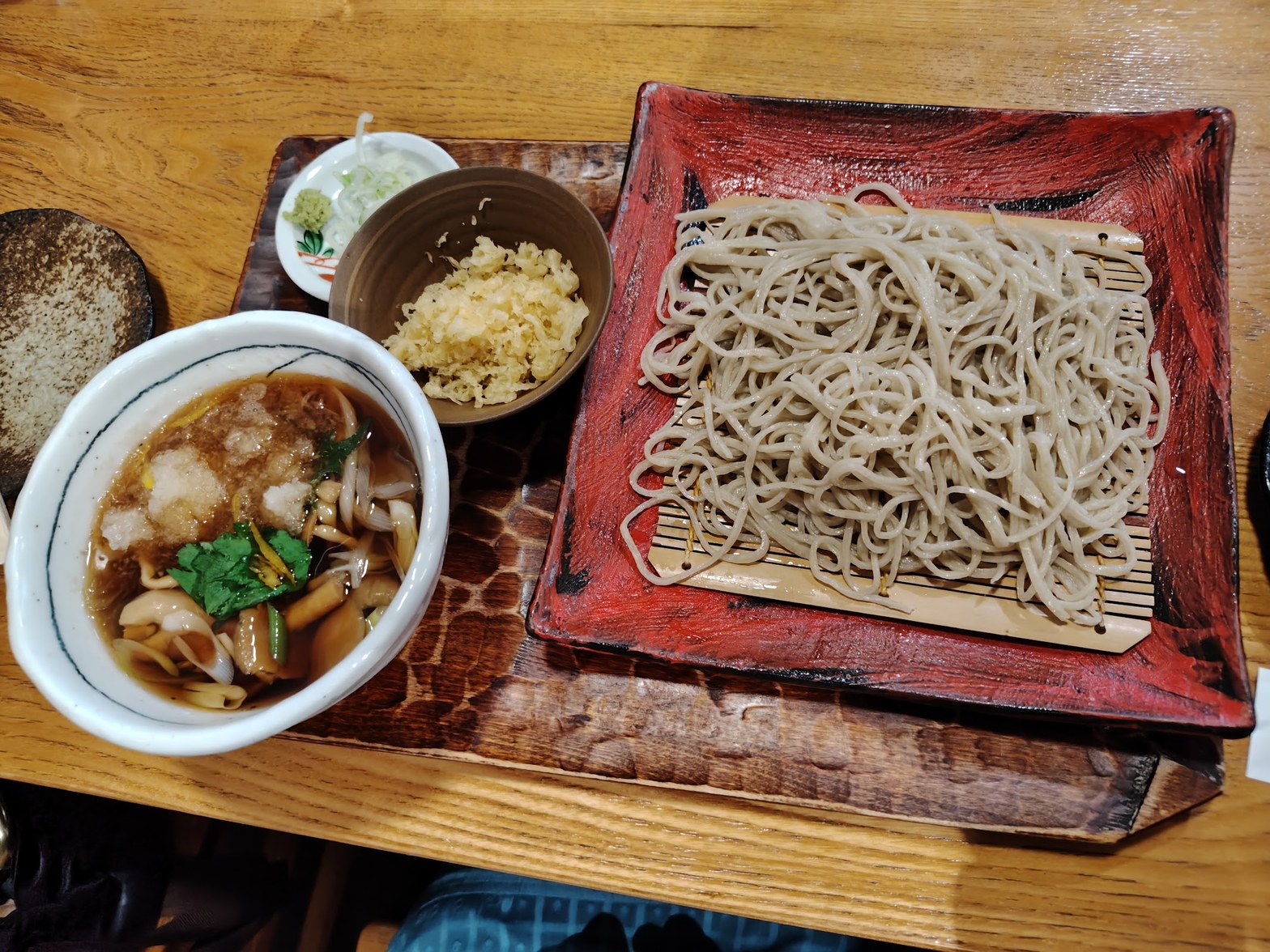 赤い角皿の蕎麦と左側に汁入り小鉢・天かす小皿が並ぶセット、俯瞰